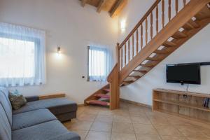 salon z kanapą, telewizorem i schodami w obiekcie Apartment Dolomiten w mieście San Martino in Badia