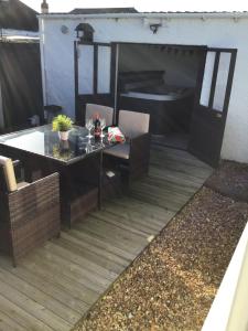 un patio con mesa y sillas en una terraza en Beach Links, en Prestatyn