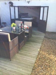 un patio con mesa, sillas, mesa y puerta en Beach Links, en Prestatyn