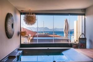 a pool in a room with a view of the ocean at Sophia Aegina in Aegina Town