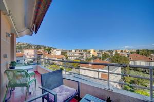 a balcony with chairs and a view of a city at Welcome to paradise in Vallauris