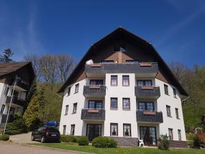 ein großes weißes Gebäude mit schwarzem Dach in der Unterkunft Haus Sachsensteinblick Ferienwohnung Sonnenschein in Bad Sachsa