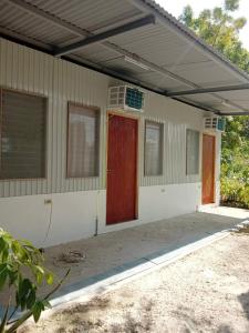 uma pequena casa com uma porta vermelha e janelas em LR Hostel and Cafe em Moalboal