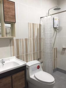 a bathroom with a toilet and a sink and a shower at Jeerang Countryside Resort in Mae Hong Son