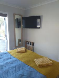 een slaapkamer met een bed met twee handdoeken erop bij Sleepout Hideaway in Rotorua