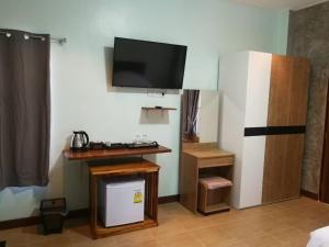 a room with a desk and a tv on the wall at Jeerang Countryside Resort in Mae Hong Son