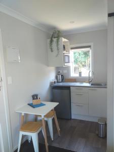 a small kitchen with a table and a sink at Sleepout Hideaway in Rotorua