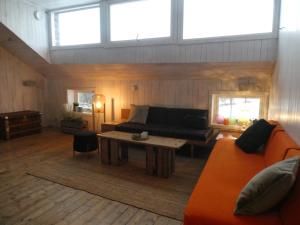 ein Wohnzimmer mit einem Sofa und einem Tisch in der Unterkunft Drengestua på Flagstad Østre in Hamar