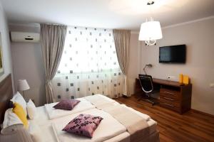 a bedroom with two beds and a desk and a window at Cabrio Apart Hotel in Cluj-Napoca