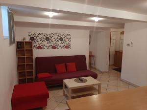ein Wohnzimmer mit einem roten Sofa und einem Tisch in der Unterkunft Apartments Lafranconi in Bratislava