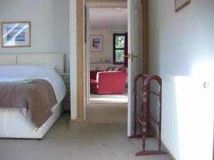 1 dormitorio con 1 cama y 1 silla roja en The Garden Apartment en Dunino