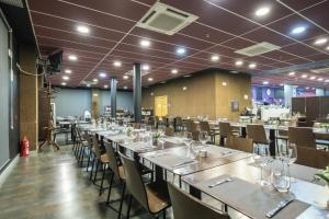 un comedor con mesas y sillas largas en Hotel Abades Via Norte en Miranda de Ebro