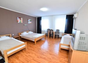 a hotel room with two beds and a television at Hostel Milkaza in Novi Sad