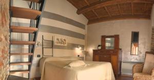 a room with a bed and a spiral staircase at Agriturismo & Agricamping Serena in Pastrengo
