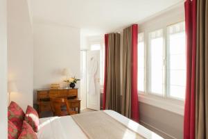 a bedroom with a bed and a window and a desk at Hôtel Parc Saint-Séverin - Esprit de France in Paris