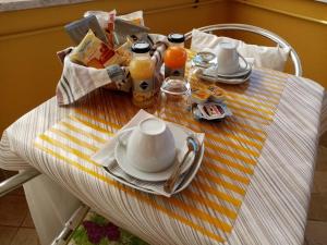 a table with a teapot and cups and plates on it at B&B La Cupella in Monterotondo