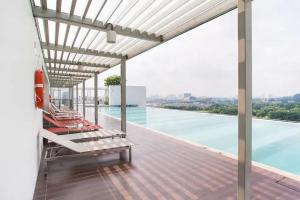 a swimming pool with chairs on the roof of a building at Suria Jelutong Studio by BeeStay in Shah Alam