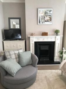 a living room with a chair and a fireplace at Lovely studios in centre in Swindon