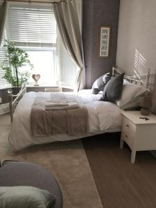 a bedroom with a large bed and a window at Lovely studios in centre in Swindon