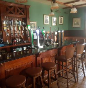 un bar con una fila de taburetes en un pub en The Parkavon Hotel en Killarney