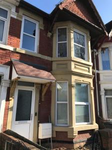 a house with a white door and windows at Lovely studios in centre in Swindon