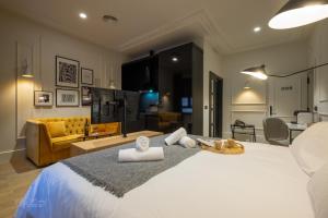 1 dormitorio con 1 cama blanca grande y sala de estar en Barbarossa Suites Plaza de España en Merida