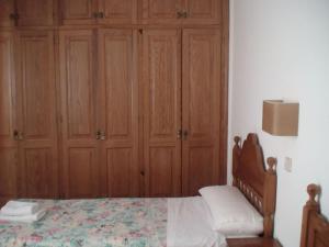 a bedroom with a bed and wooden cabinets at Apartamentos Rocas Marinas in Punta Grossa