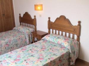 Un dormitorio con 2 camas y una mesa con una falda. en Apartamentos Rocas Marinas, en Punta Grossa