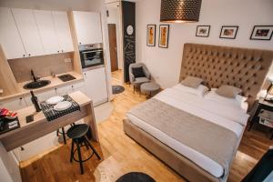 a bedroom with a large bed and a kitchen at Apartments Doclea in Podgorica