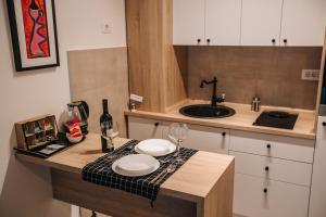 uma cozinha com um balcão com 2 copos e um lavatório em Apartments Doclea em Podgorica