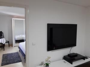 Lemon Tree House في لوسادا: غرفة معيشة مع تلفزيون بشاشة مسطحة على جدار