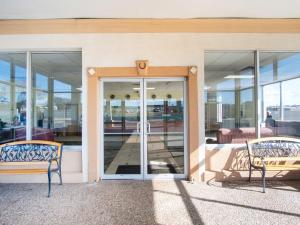 two benches in front of a building with glass doors at OYO Hotel Oklahoma City South I-35 and SE 29th in Oklahoma City