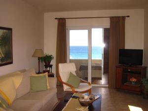 un soggiorno con divano e vista sull'oceano di Spacious Seafront Apartment a Ixiá