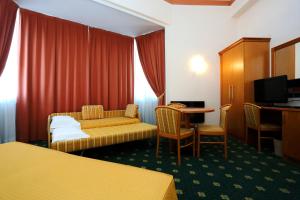 a hotel room with a bed and a couch and a table at Hotel Estense in Modena