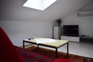 ein Wohnzimmer mit einem Couchtisch und einem TV in der Unterkunft Apartment Eve in Klimno