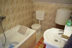 ein Badezimmer mit Toilette, Badewanne und Waschbecken in der Unterkunft Apartment Eve in Klimno + 25 Fotos