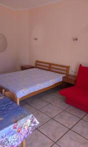 1 Schlafzimmer mit 2 Betten und einem roten Stuhl in der Unterkunft Apartments Olga in Tivat