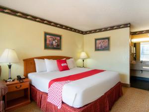 una habitación de hotel con una cama grande con almohadas rojas en OYO Hotel Oklahoma City South I-35 and SE 29th, en Oklahoma City
