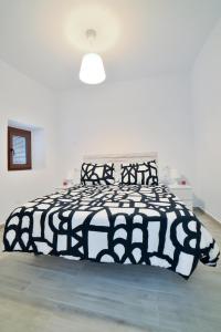 uma cama preta e branca num quarto branco em Casa Luminosa, junto al Castillo em Vejer de la Frontera