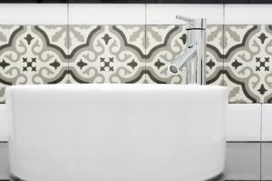 a bathroom with a white sink and a faucet at Apartamentos Suites Roma in Merida +34 photos