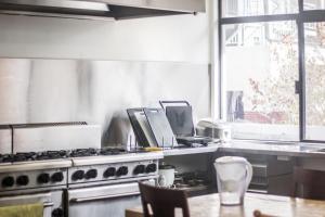 a kitchen with a stove and a table and a window at Downtown Backpackers Hostel Perth - note - Valid Passport required for check in in Perth