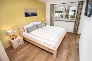 sypialnia z łóżkiem i oknem w obiekcie Ferienwohnungen "Zur Wally" w Garmisch Partenkirchen