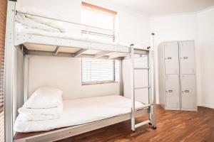 a bunk bed in a room with a ladder at Downtown Backpackers Hostel Perth - note - Valid Passport required for check in in Perth +4 photos