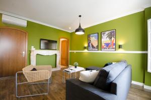 梅里達的住宿－Apartamentos Suites Roma，客厅设有绿色的墙壁和沙发