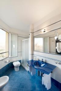 bagno blu con lavandino e servizi igienici di Hotel Estense a Modena