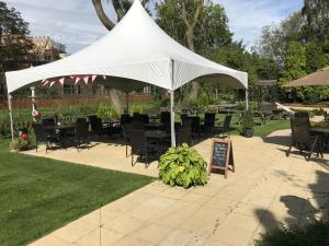 a white tent with chairs and tables and a sign at The White Lion Inn in Oakham