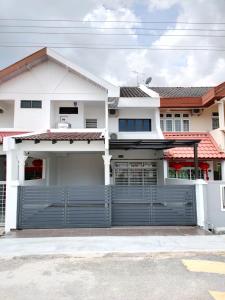une maison blanche avec une porte de garage bleue dans l'établissement 58 Kota Laksamana - Near Jonker Street for 10 to 15 Pax, à Malacca