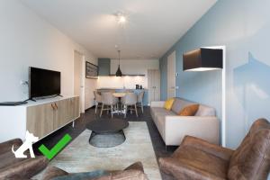 ein Wohnzimmer mit einem Sofa und einem Tisch in der Unterkunft Hotel Kaap West I Kloeg Collection in Westkapelle