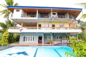 a villa with a swimming pool in front of a house at Blue Haven Guest House in Kandy