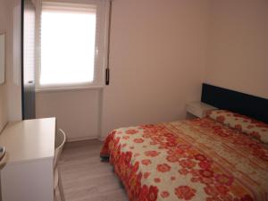 una piccola camera con letto e finestra di Stiria a Lignano Sabbiadoro